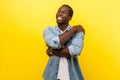 I love myself. Portrait of self-satisfied happy man cuddling himself. indoor studio shot isolated on yellow background