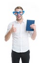 I love reading books. Man cute nerd in heart shaped glasses loves to read books. Guy holds book and shows thumbs up