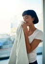 I love the smell of my fabric softener. a young woman smelling freshly washed towels at home. Royalty Free Stock Photo