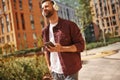 I love that song. Cheerful young man with stubble in headphones listening to the music and holding mobile phone while Royalty Free Stock Photo