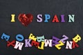 I love SPANISH word on black board background composed from colorful abc alphabet block wooden letters, copy space for