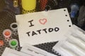 I love tattoo. The text is written on a small sheet of paper among various equipment for tattooing Royalty Free Stock Photo