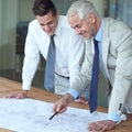 I love what youve done here. two architects looking at blueprints in an office.