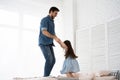 I love you, dad! Handsome young man at home with his little girl are having fun and jumping on bed. Happy Father`s Day! Royalty Free Stock Photo