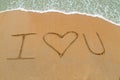 I Love You drawn on sandy beach with wave approaching Royalty Free Stock Photo