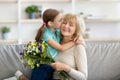 Little girl kissing and greeting woman with flowers Royalty Free Stock Photo