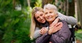 I love you mom. a cheerful elderly woman in a wheelchair spending time with her daughter outside in a park. Royalty Free Stock Photo