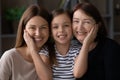 Affectionate tween girl caress cheeks of retired grandmother young mother