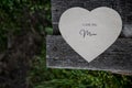 I love You Mum text written on a heart-shaped card on a rustic old bench Royalty Free Stock Photo
