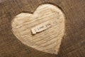 I love you - tiny typed text note close up. Valentines Day greetings concept. Carved heart shape on wood as background for Royalty Free Stock Photo