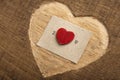 I love you - tiny typed text note close up. Valentines Day greetings concept. Carved heart shape on wood as background for Royalty Free Stock Photo