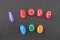 I love you message with multi colored stones letters over black volcanic sand Royalty Free Stock Photo