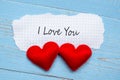 I LOVE YOU word on paper note with couple red heart shape decoration on blue wooden table background. Wedding, Romantic and Happy Royalty Free Stock Photo