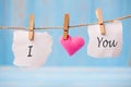 I LOVE YOU word on paper and pink heart shape decoration hanging on line with copy space for text on blue wooden background. Love Royalty Free Stock Photo