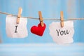I LOVE YOU word on paper and red heart shape decoration hanging on line with copy space for text on blue wooden background. Love, Royalty Free Stock Photo