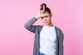 I`m loser. Portrait of brunette teen girl making loser gesture on forehead, upset about failure. studio shot isolated on pink