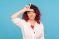 I`m loser! Portrait of unlucky depressed hipster woman with fancy red hair showing L sign on forehead