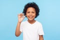 I`m okay! Portrait of adorable joyful little boy with curly hair in white T-shirt showing ok hand gesture and smiling