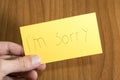 I`m sorry handwrite on a yellow paper with a pen on a table