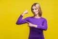 I`m strong. Portrait of proud successful businesswoman pointing at biceps. studio shot isolated on yellow background