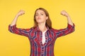 I`m strong woman! Portrait of self-confident ginger girl in casual shirt raising hands showing power and strength, feeling