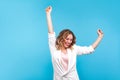 I`m winner! Portrait of ecstatic overjoyed lady dancing with raised arms, smiling excitedly. blue background