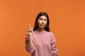 I mean this. Portrait of beautiful woman in pink sweater looking away and raising index finger, having bright idea or pointing Royalty Free Stock Photo