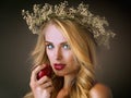 I must have it. Studio shot of a gorgeous young woman eating a red apple against a dark background.