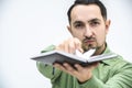 Closeup shot of exhausted man tearing out a page from his personal organizer with schedule and plans. Royalty Free Stock Photo