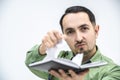 Closeup shot of exhausted man tearing out a page from his personal organizer with schedule and plans. Royalty Free Stock Photo