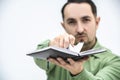 Closeup shot of exhausted man tearing out a page from his personal organizer with schedule and plans. Royalty Free Stock Photo