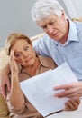 I need my glasses, Im seeing double. a unhappy senior couple looking at documents together. Royalty Free Stock Photo