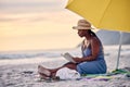 I need to be saved too... a beautiful young woman relaxing with a book at the beach. Royalty Free Stock Photo