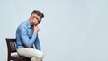 I need to think. Side view of handsome bearded man in casual clothes and sunglasses touching his chin while sitting on Royalty Free Stock Photo