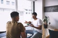 I need your advice about something. two young men talking while having coffee together in a cafe. Royalty Free Stock Photo