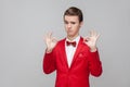 I am ok, approval. Portrait of trendy young gentleman wearing red tuxedo and bow tie showing okay