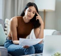 I overspent this month. an attractive young woman sitting alone in her living room and feeling stressed while Royalty Free Stock Photo