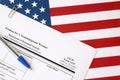 I-129 Petition for a nonimmigrant worker blank form lies on United States flag with blue pen from Department of Homeland Security