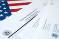 I-129 Petition for a nonimmigrant worker blank form lies on United States flag with envelope from Department of Homeland Security