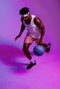 I play the game and I play it well. Purple filtered shot of a sporty young man playing basketball.