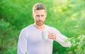 I prefer green tea. Refreshing drink. Man bearded tea farmer hold mug nature background. Green tea contains bioactive