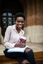 I prepare some information. Portrait of beautiful young afro american student woman sitting outside on the bench writing in book a Royalty Free Stock Photo