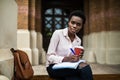 I prepare some information. Portrait of beautiful young afro american student woman sitting outside on the bench writing in book a Royalty Free Stock Photo