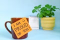 I am proud of you words of encouragement concept. Selective focus of a cup of coffee with handwritten bright paper message note.