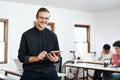 I refuse to give up on my dreams. Cropped portrait of a handsome young businessman using a tablet while his colleagues Royalty Free Stock Photo