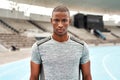 I refuse to quit. Cropped portrait of a handsome young athlete standing alone before going for a run on a track field.