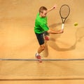 The one jumping player, caucasian fit man, playing tennis on the earthen court