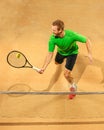 The one jumping player, caucasian fit man, playing tennis on the earthen court