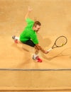 The one jumping player, caucasian fit man, playing tennis on the earthen court
