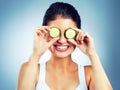 I see all things healthy. Studio shot of an attractive young woman holding cucumber slices over her eyes.